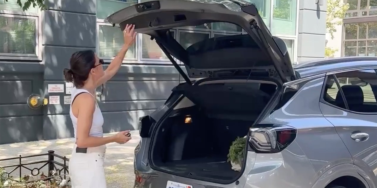 Influencer Eden Grinshpan Opening the Liftgate of a Silver 2025 Buick Encore GX Avenir SUV