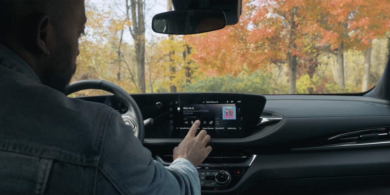 Rick Southers Operating the Infotainment System in a Buick Envista with Autumn Trees in the Background