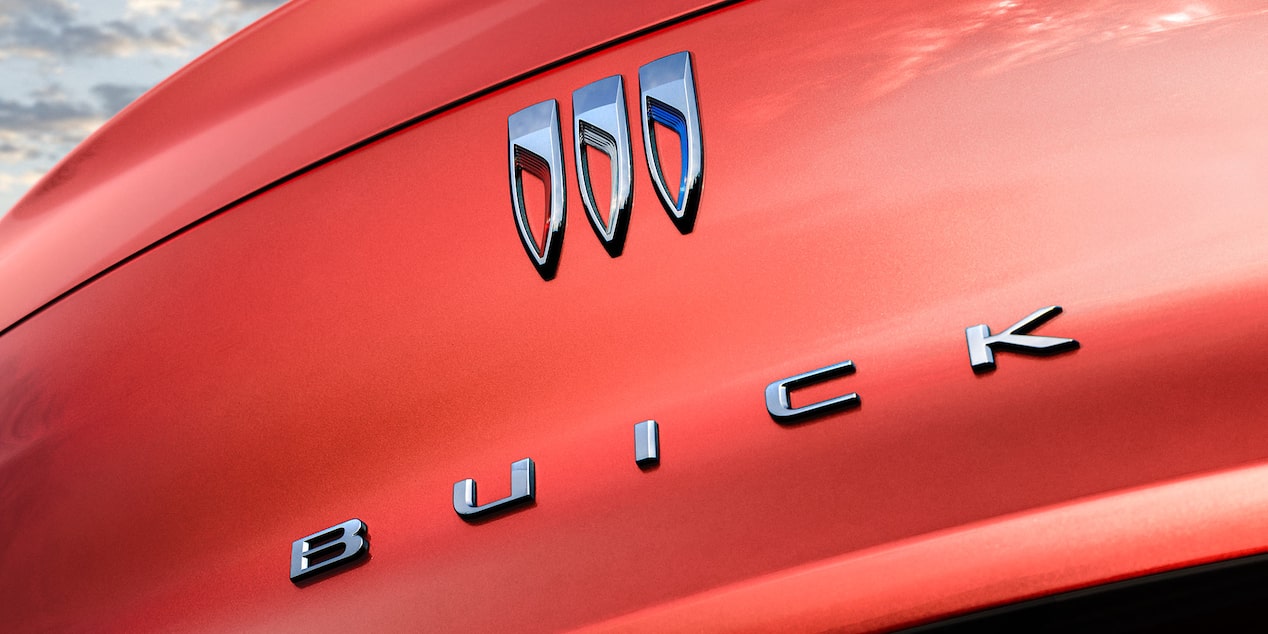 A Close-Up View of the Chrome Buick Logo and Wordmark on a Red Vehicle