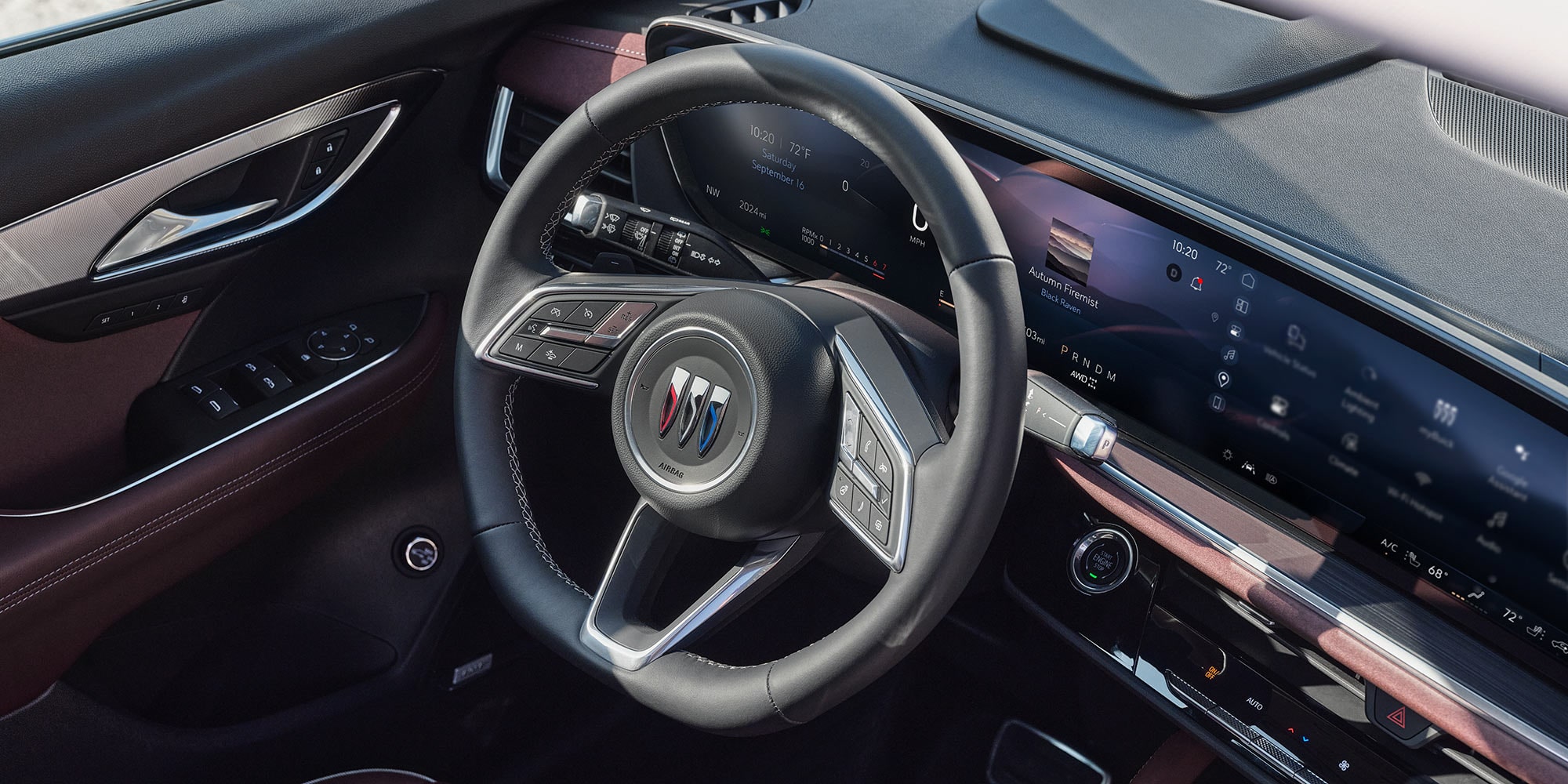 The Interior Dashboard of a Buick Vehicle Showing the Steering Wheel with the Buick Logo and a Widescreen Digital Display 