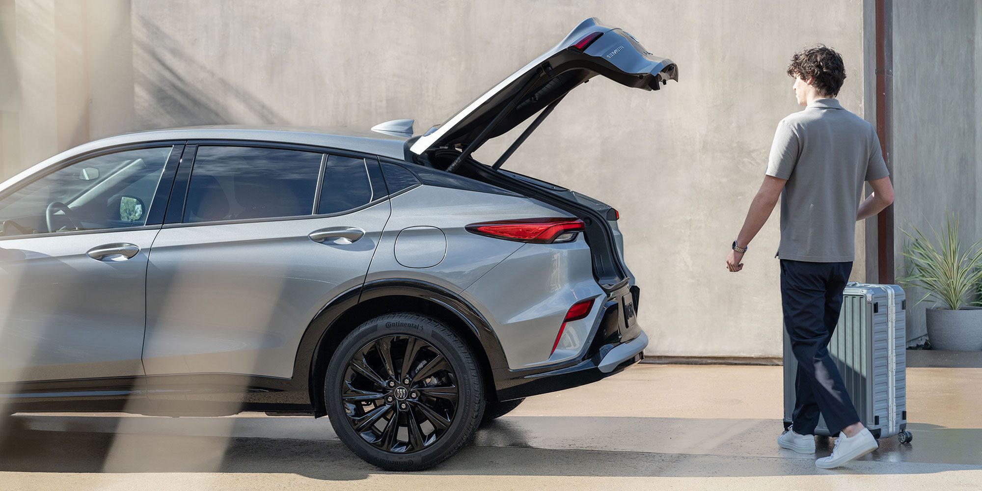 A Man Loading his Luggage into the Open Trunk of the Buick Envista