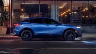 Profile View of a Blue Buick Envista Compact Crossover Parked at Night on a City Street