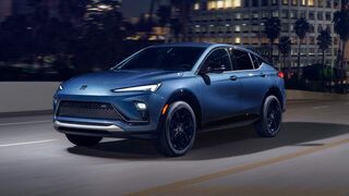 Front Three-Quarters View of the Buick Envista Driving Down a City Street at Night