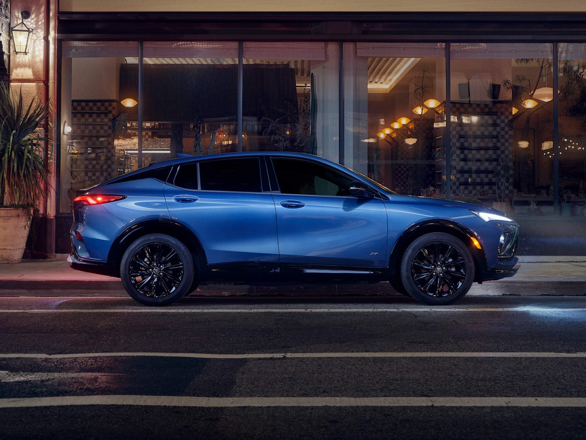 Profile View of the Buick Envista Compact SUV Parked on a City Street at Night