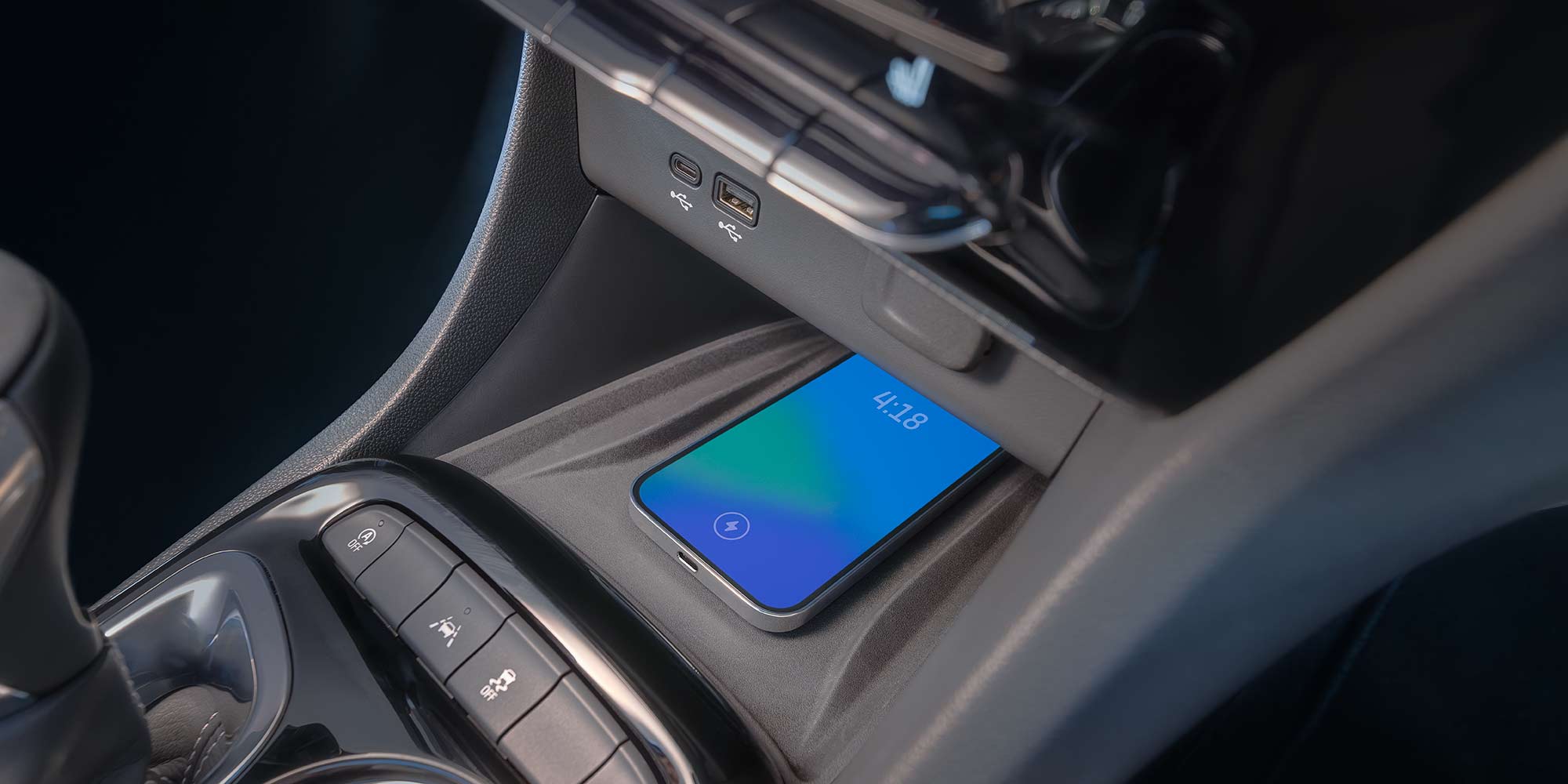 A Smartphone Wirelessly Charges in the Center Console of a Buick SUV, Showing the Time 4:18
