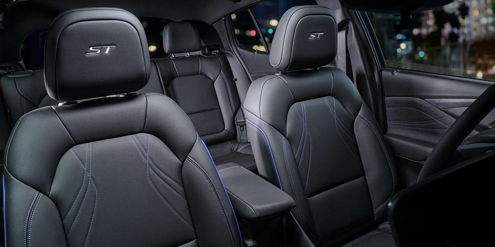 The Interior of a Buick SUV Featuring Black Leather Seats with Blue Stitching and an ST Logo