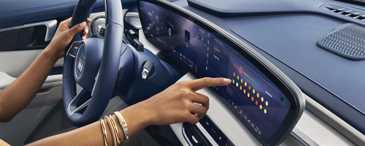 Close-up of a Woman Driving a Buick Enclave While Using the Touchscreen on the Infotainment System