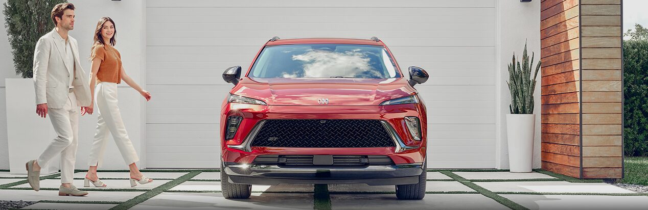 Man and Woman Walking Towards Red Buick Parked in Driveway