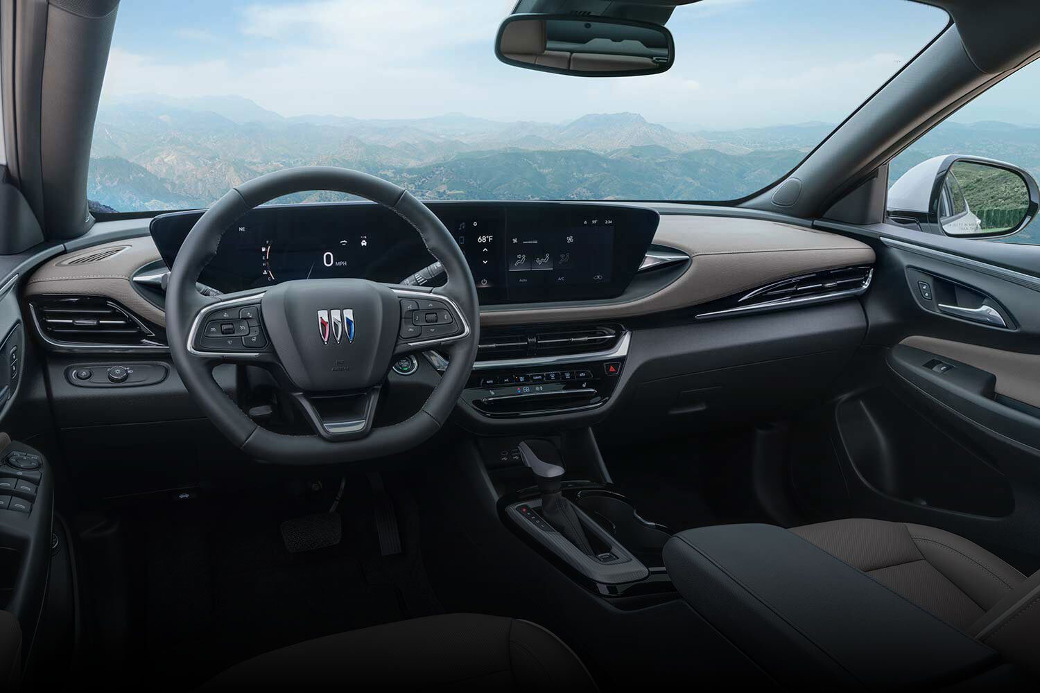 A Gray Buick Envista Avenir SUV Parked on a Gravel Driveway with Mountains in the Background