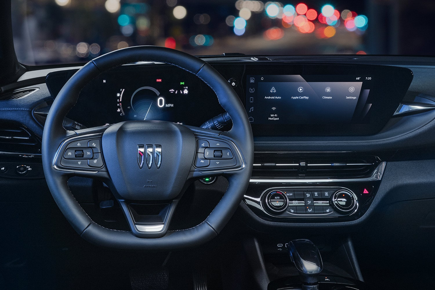 A Buick Car Interior at Night with the Steering Wheel and Infotainment Screen Displaying Apps