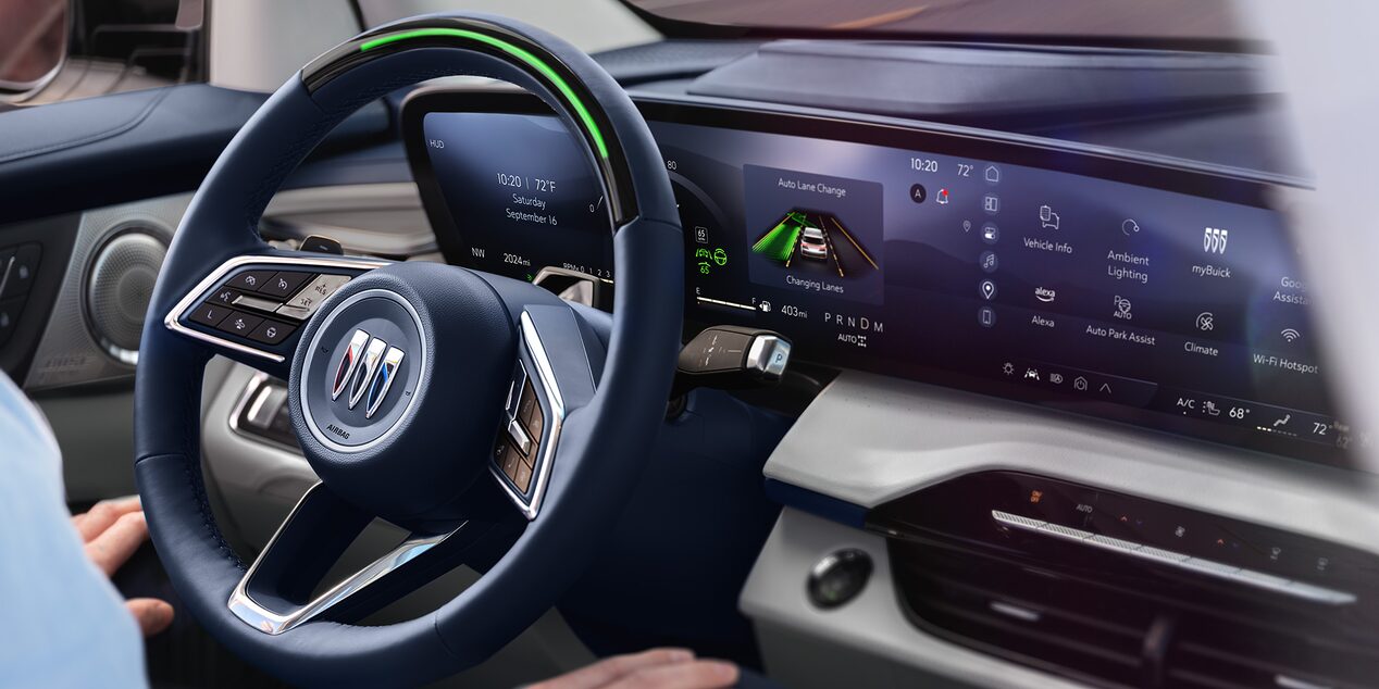 Close-up of the Steering Wheel and the Infotainment Screen with a Man Sitting in the Driver’s Seat of a 2025 Buick Enclave with SuperCuise in Use