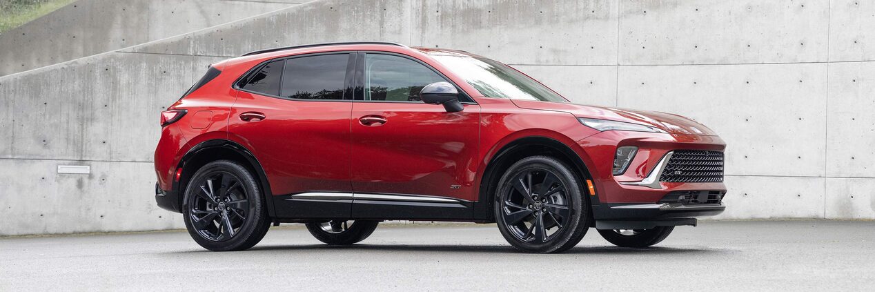 Wide Side View of a 2025 Buick Envision ST Sporty Crossover in an Empty Parking Lot
