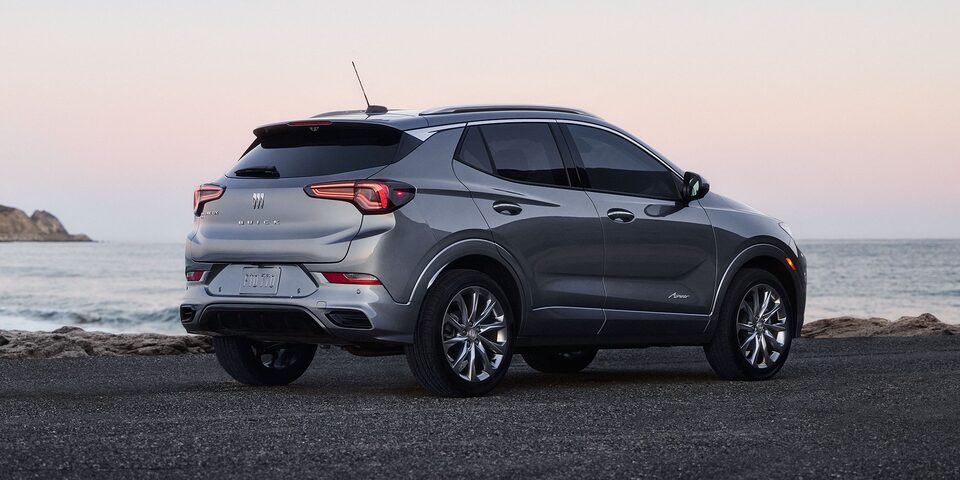 Rear Three-Quarters View of the 2026 Buick Encore GX Avenir Luxury SUV Parked on the Beach at Sunset