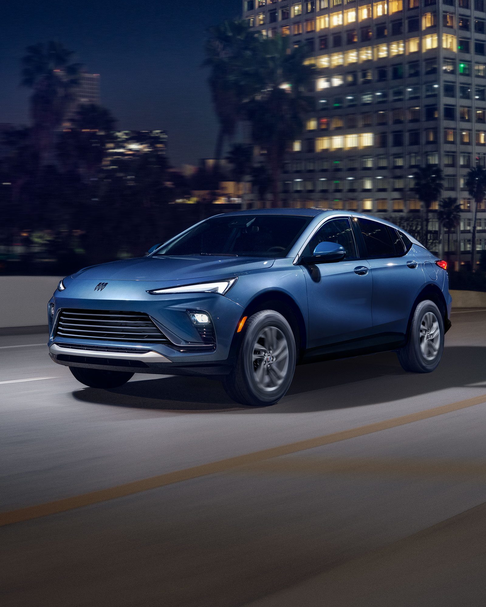 Three-quarters View of the 2026 Buick Envista Driving Out of the City Under a Street Light