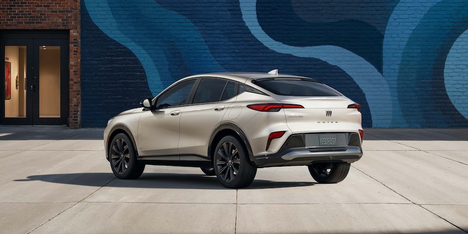 Rear View of the 2026 Buick Envista ST SUV with the Studio Series Package Parked Next to a City Building Covered with a Colorful Abstract Mural