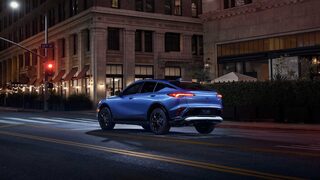 Three-quarters Rear View of the 2026 Buick Envista Driving Down Through the City at Night