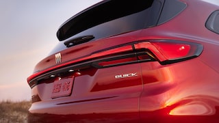 La vue arrière d’un VUS Buick Enclave rouge 2027 avec le logo et la plaque d’immatriculation Buick 2027 affichés