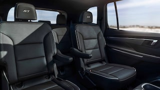 Les sièges arrière d’un véhicule Buick Enclave 2027 avec vue sur l’océan par la fenêtre.