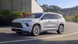 Un VUS blanc Buick Enclave Avenir 2027 roulant sur une route courbe