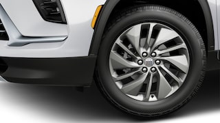 La roue avant d’une Buick Enclave blanche 2027 avec une jante en alliage multi-rayons et un pneu noir